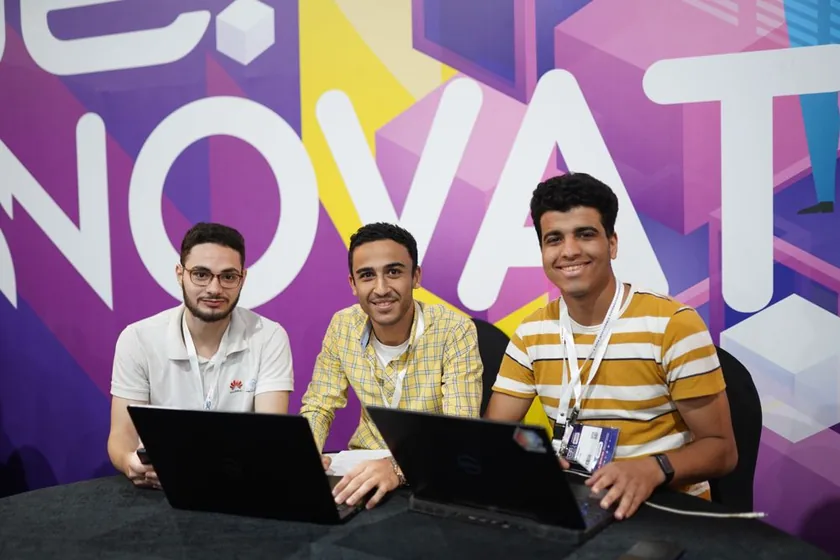 Three participants coding at the hackathon
