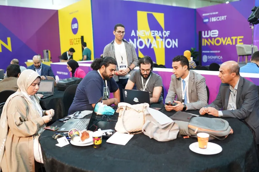 Teams working at their tables with mentors